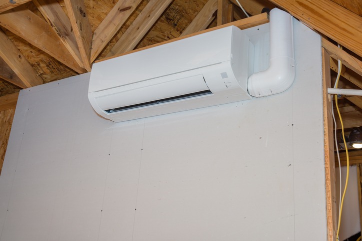 Mini-split ductless air conditioning unit installed in unfinished room