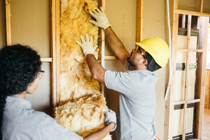 Construction workers fitting insulation